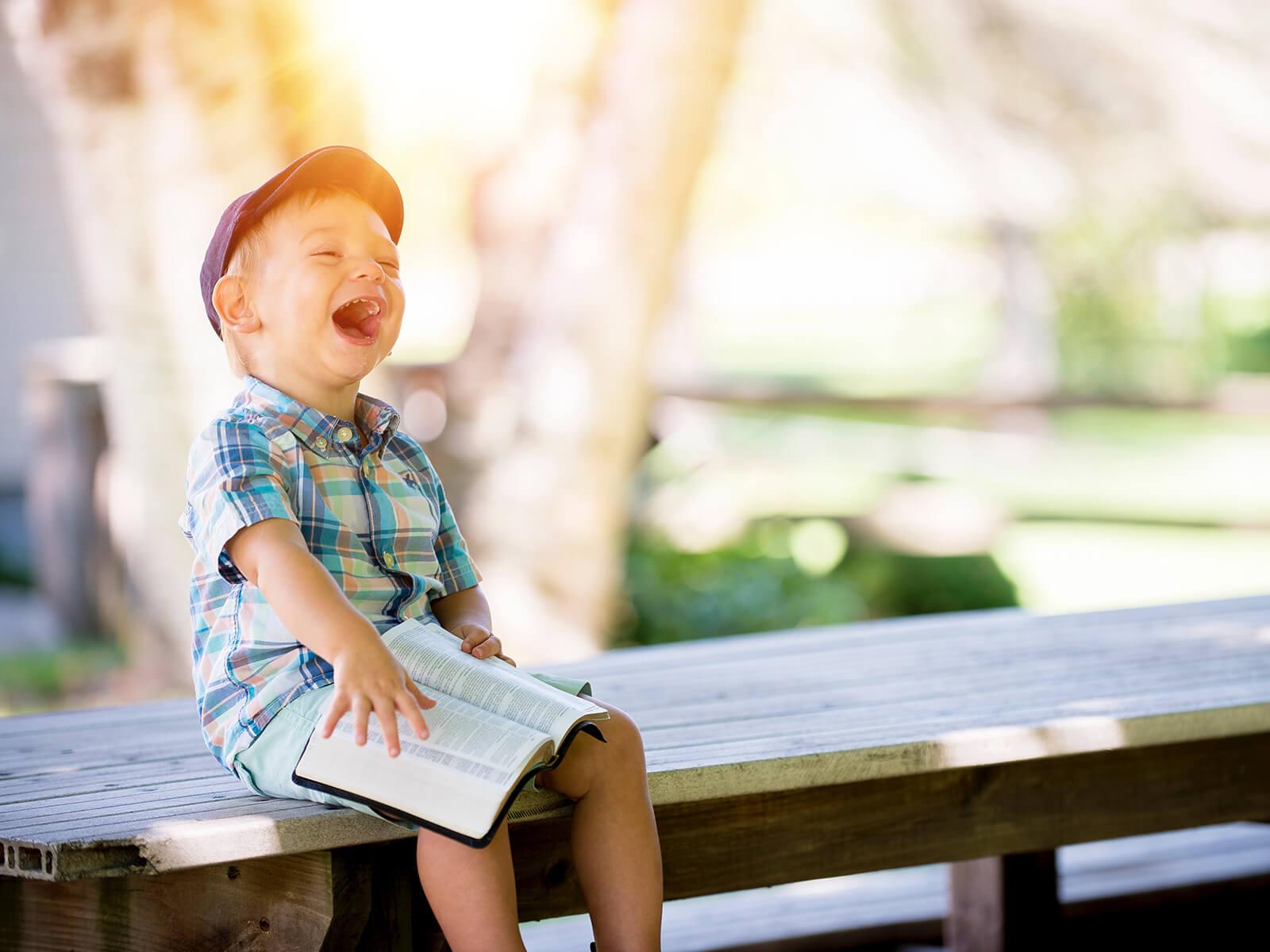 Lachendes Kind auf einer Bank